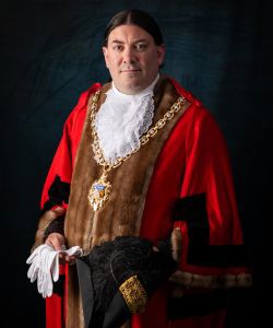 Cllr Dr David Willingham wearing red and black mayor's robes and chain